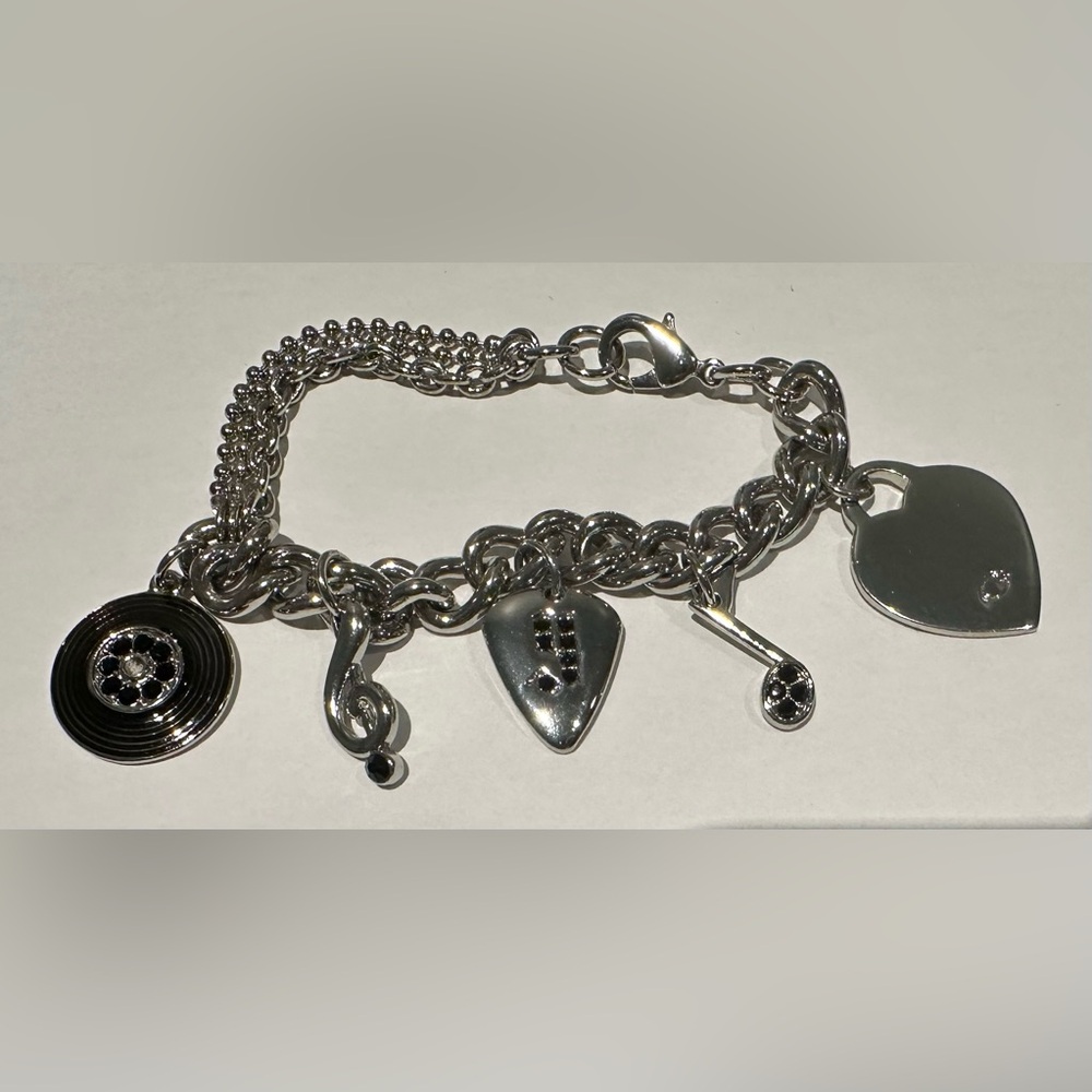 Guess charm bracelet with heart charm and notes charm.